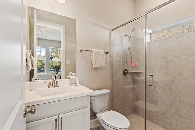 bathroom featuring a shower stall, toilet, and vanity