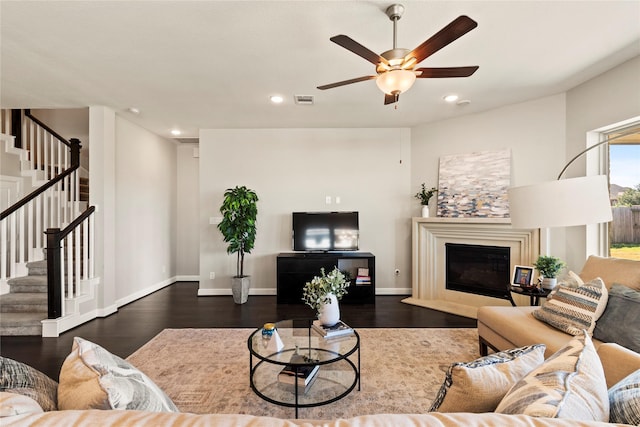 living room featuring stairway, wood finished floors, a ceiling fan, recessed lighting, and a glass covered fireplace