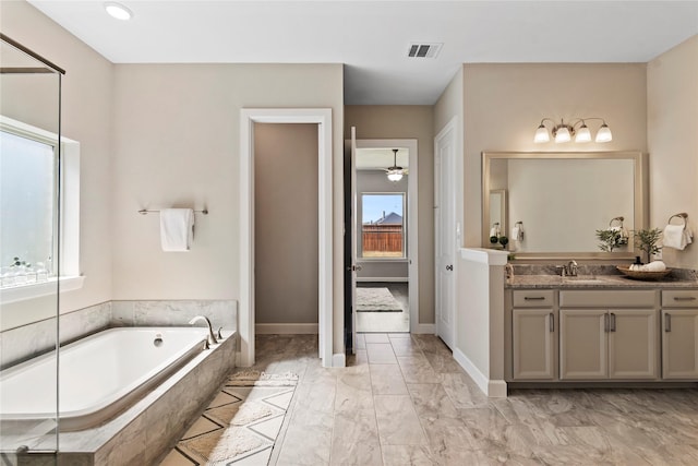 full bathroom featuring a bath, vanity, marble look tiles, baseboards, and ceiling fan