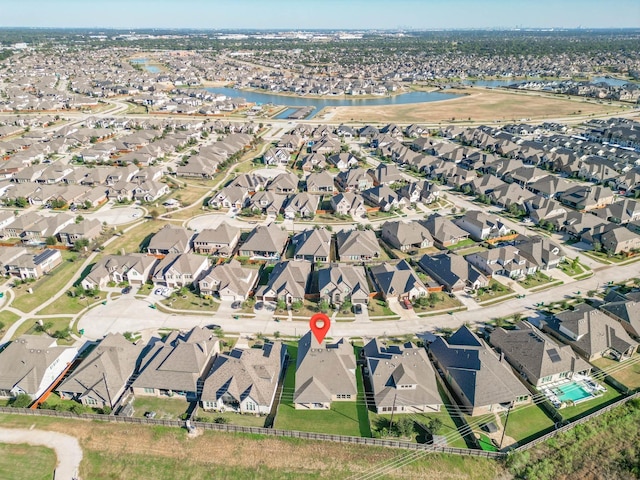 aerial view of property's location featuring a large body of water and nearby suburban area