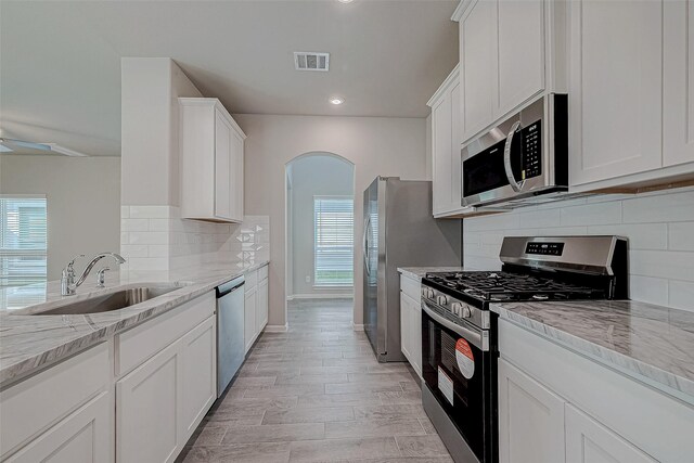 27322 Axis Deer Trl, Magnolia, TX 77354 - kitchen with appliances with stainless steel finishes, a sink, healthy amount of natural light, white cabinetry, and recessed lighting