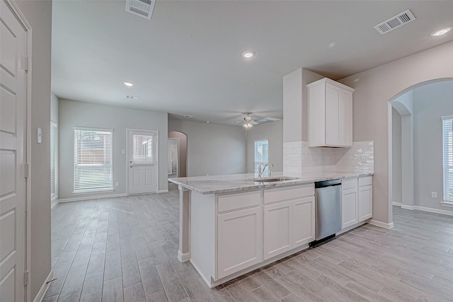 27322 Axis Deer Trl, Magnolia, TX 77354 - kitchen with stainless steel dishwasher, arched walkways, a sink, a ceiling fan, and light wood-style flooring