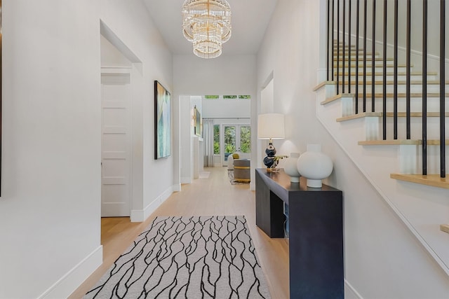 208 Heron Pointe Dr, Montgomery, TX 77316 - hall featuring a chandelier, wood finished floors, baseboards, and stairs