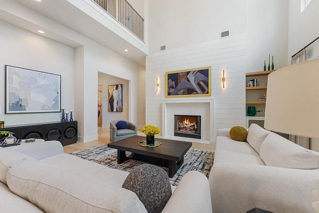 208 Heron Pointe Dr, Montgomery, TX 77316 - living area featuring a towering ceiling, wood finished floors, recessed lighting, a fireplace with flush hearth, and baseboards