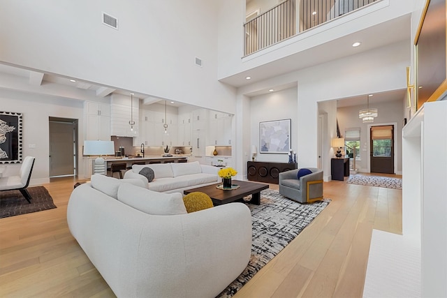 208 Heron Pointe Dr, Montgomery, TX 77316 - living room featuring a high ceiling, light wood-style floors, baseboards, and recessed lighting