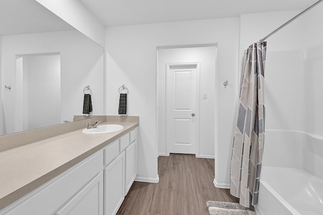 7826 Switchgrass Creek Dr, Katy, TX 77493 - bathroom with wood finished floors, baseboards, vanity, and shower / bath combo