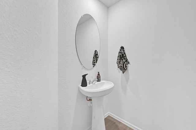 7826 Switchgrass Creek Dr, Katy, TX 77493 - bathroom with wood finished floors, baseboards, and a textured wall
