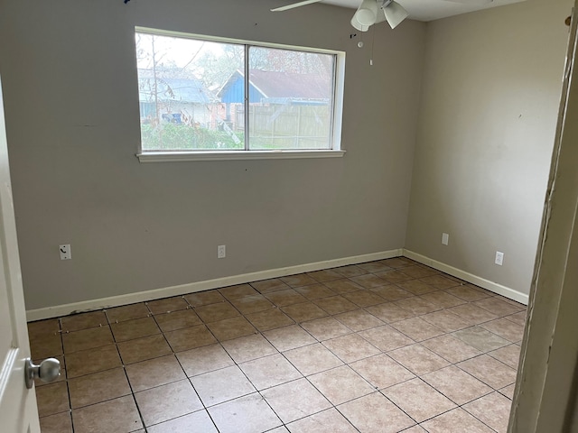 unfurnished room featuring light tile patterned floors, ceiling fan, and baseboards