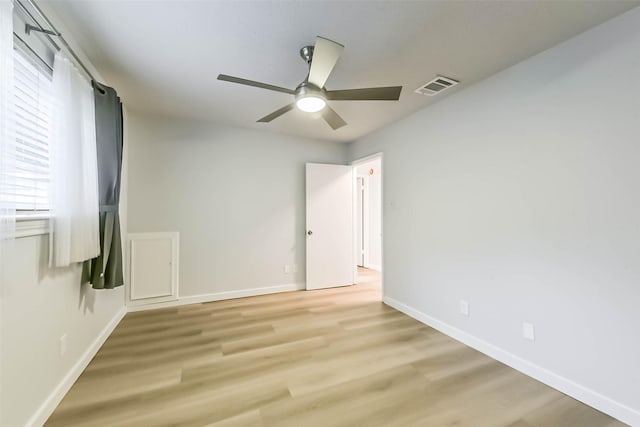 spare room with a ceiling fan, baseboards, and light wood-style flooring