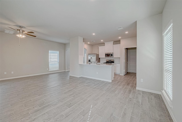 10256 Badger Run Ln, Magnolia, TX 77354 - unfurnished living room featuring light wood-type flooring, a ceiling fan, baseboards, and recessed lighting