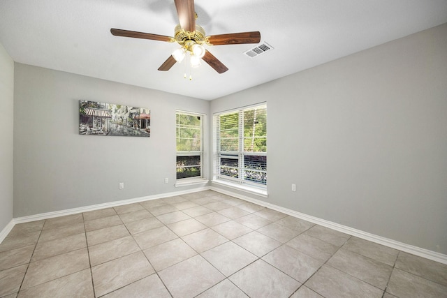 empty room featuring a ceiling fan, baseboards, and light tile patterned floors