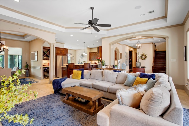 39 New Oak Trl, Humble, TX 77346 - living room featuring a raised ceiling, arched walkways, ornate columns, wine cooler, and ornamental molding