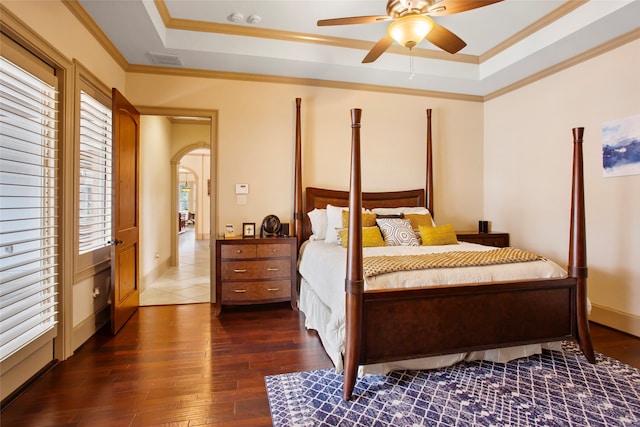 39 New Oak Trl, Humble, TX 77346 - bedroom with a raised ceiling, dark wood-style floors, arched walkways, crown molding, and a ceiling fan