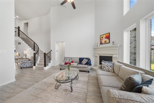 1711 Country Air Ln, Missouri City, TX 77459 - living area featuring a towering ceiling, ceiling fan, plenty of natural light, a fireplace with raised hearth, and wood finished floors
