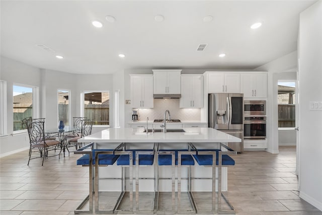 1711 Country Air Ln, Missouri City, TX 77459 - kitchen with stainless steel appliances, a breakfast bar area, baseboards, decorative backsplash, and recessed lighting