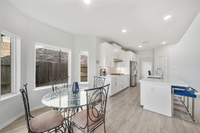 1711 Country Air Ln, Missouri City, TX 77459 - kitchen featuring stainless steel appliances, a sink, an island with sink, white cabinets, and recessed lighting