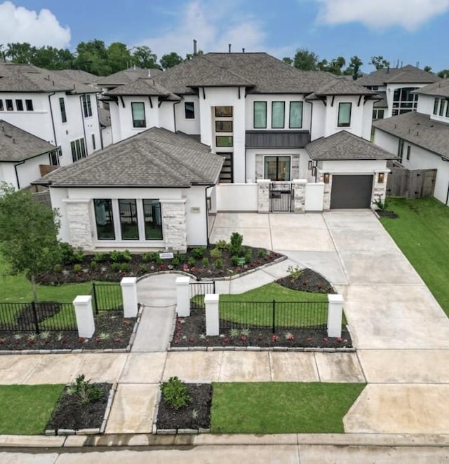 8911 Orchard Cv, Missouri City, TX 77459 - view of front facade with stone siding, a gate, driveway, a garage, and stucco siding