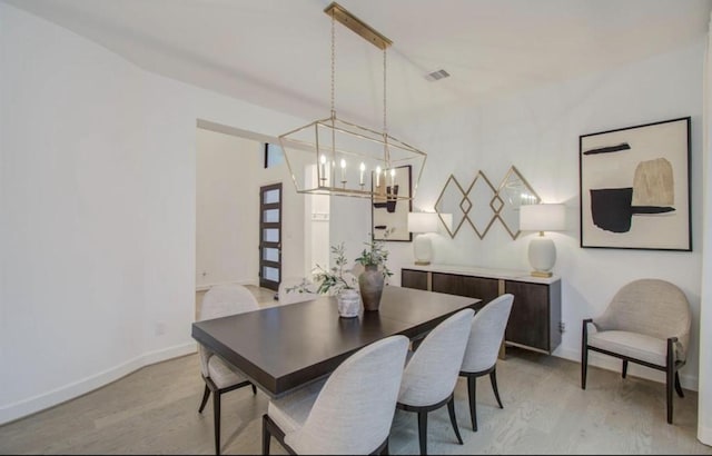 8911 Orchard Cv, Missouri City, TX 77459 - dining room with light wood-style floors, a chandelier, and baseboards