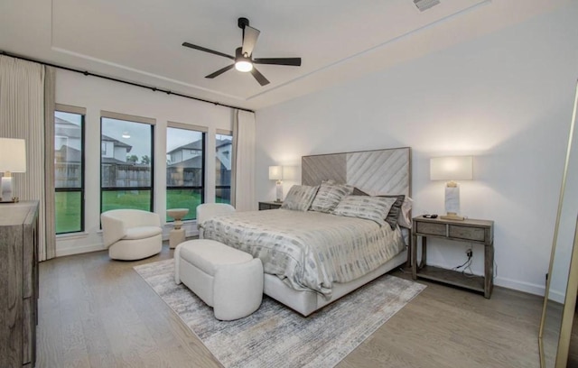 8911 Orchard Cv, Missouri City, TX 77459 - bedroom with light wood-style floors, a ceiling fan, and baseboards