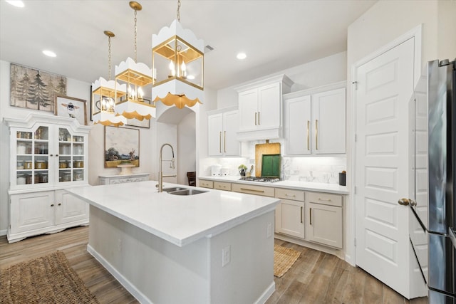7918 Silver Grove Dr, Magnolia, TX 77354 - kitchen with a sink, light countertops, a kitchen island with sink, gas cooktop, and a chandelier