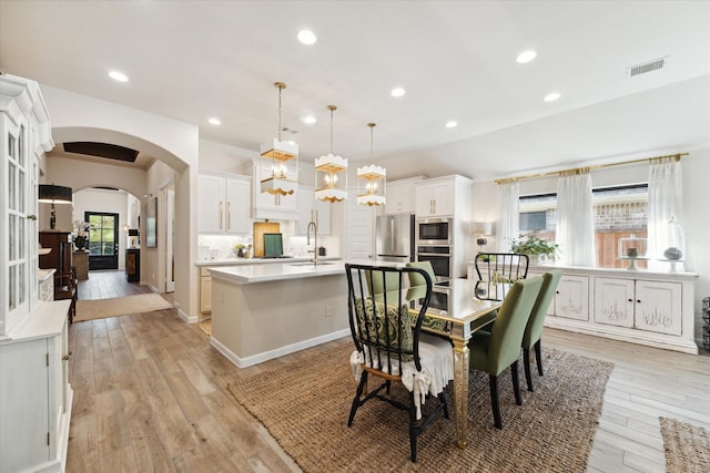 7918 Silver Grove Dr, Magnolia, TX 77354 - dining space with arched walkways, light wood-style floors, and recessed lighting