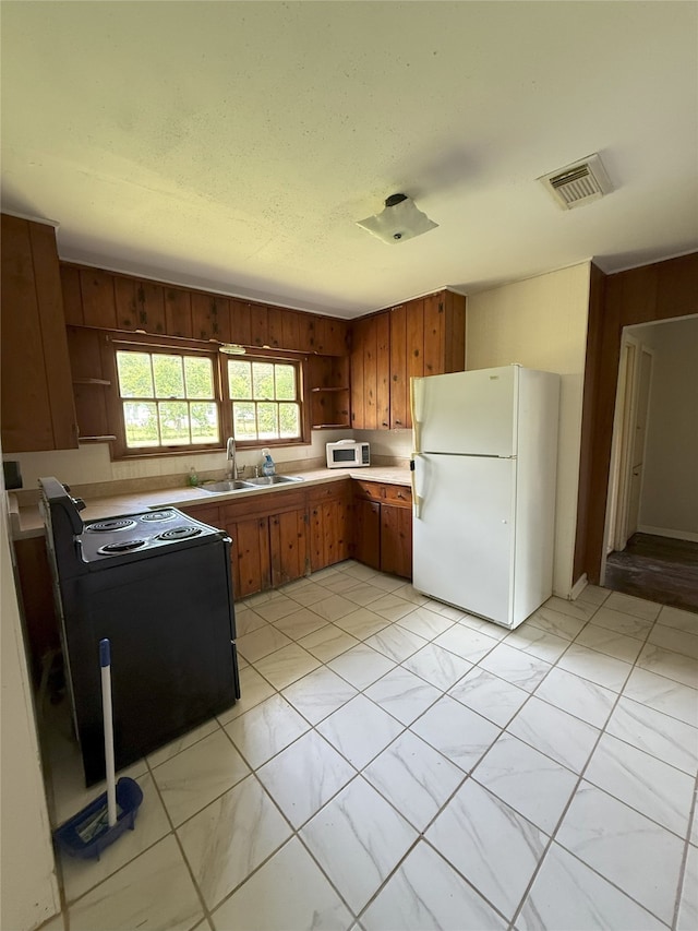 1510 Oleander Dr, La Marque, TX 77568 - kitchen with white appliances, open shelves, a sink, brown cabinetry, and wooden walls