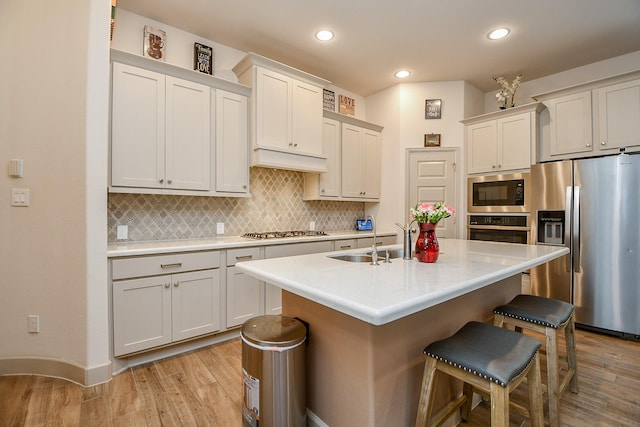 2543 Summer Peach St, Katy, TX 77494 - kitchen featuring stainless steel appliances, a kitchen bar, light wood finished floors, backsplash, and recessed lighting