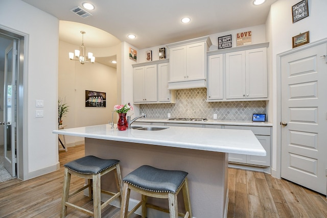 2543 Summer Peach St, Katy, TX 77494 - kitchen with a sink, light wood finished floors, stainless steel gas stovetop, a kitchen breakfast bar, and recessed lighting