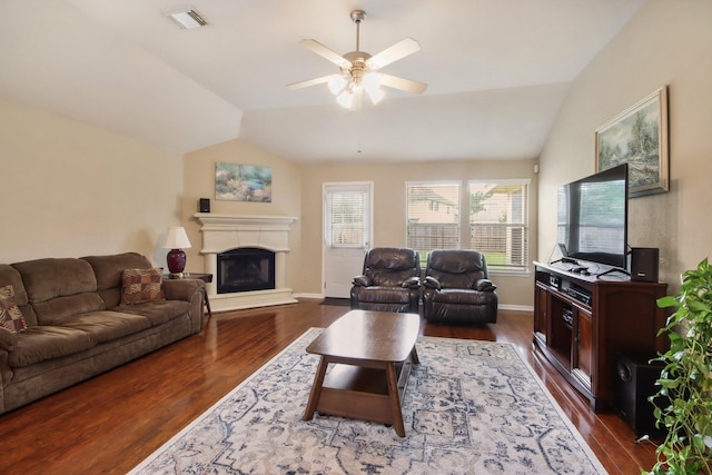 13614 Brighton Park Dr, Houston, TX 77044 - living room featuring lofted ceiling, dark wood finished floors, a ceiling fan, a fireplace with raised hearth, and baseboards