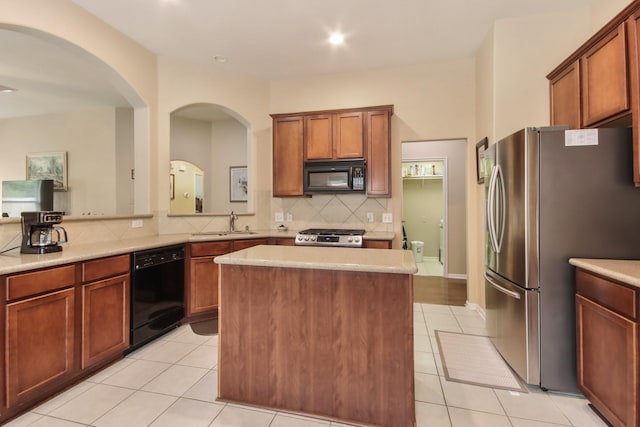 13614 Brighton Park Dr, Houston, TX 77044 - kitchen featuring black appliances, a sink, backsplash, light tile patterned flooring, and light countertops