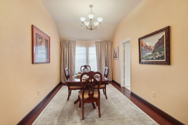 13614 Brighton Park Dr, Houston, TX 77044 - dining area featuring a chandelier, dark wood finished floors, lofted ceiling, and baseboards