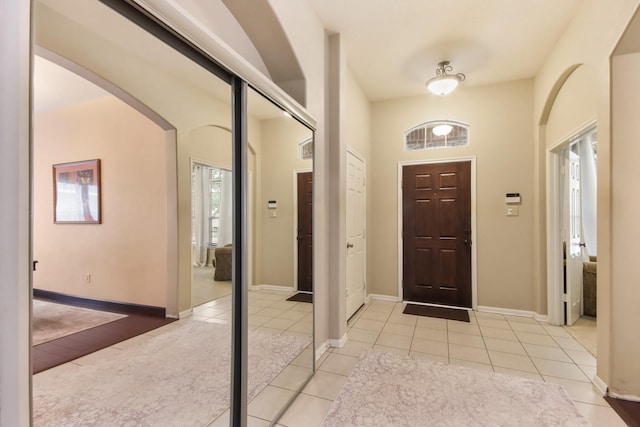 13614 Brighton Park Dr, Houston, TX 77044 - foyer with arched walkways, light tile patterned floors, and baseboards