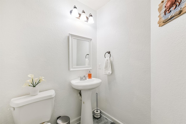 bathroom featuring baseboards and toilet