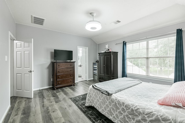 bedroom featuring wood finished floors, lofted ceiling, and baseboards
