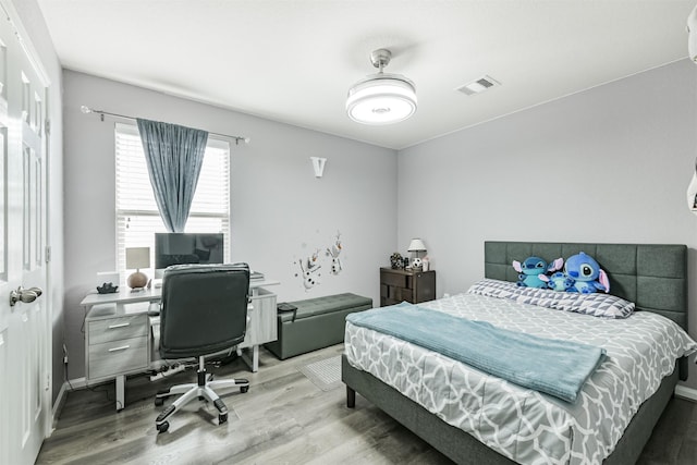 bedroom with wood finished floors and a desk