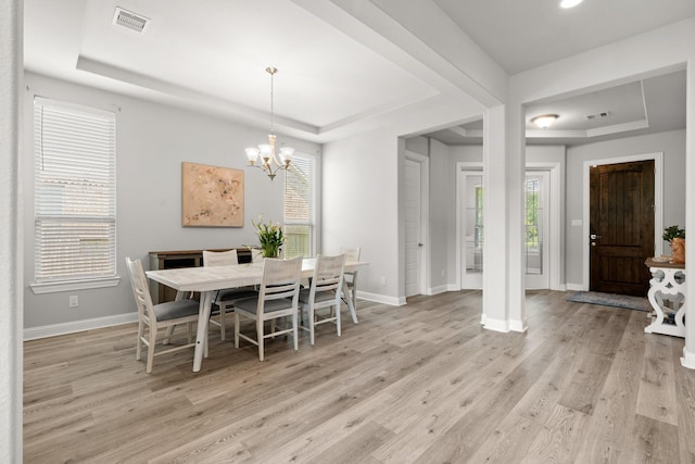 dining area with a raised ceiling, plenty of natural light, a chandelier, light wood-style flooring, and recessed lighting