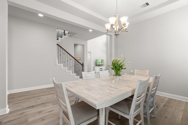 dining area with light wood-type flooring, a chandelier, stairs, baseboards, and recessed lighting
