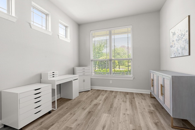 unfurnished office with light wood-style flooring and baseboards
