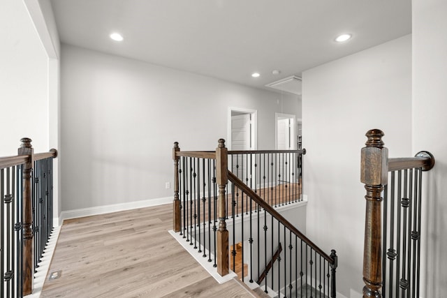 stairway with attic access, wood finished floors, baseboards, and recessed lighting
