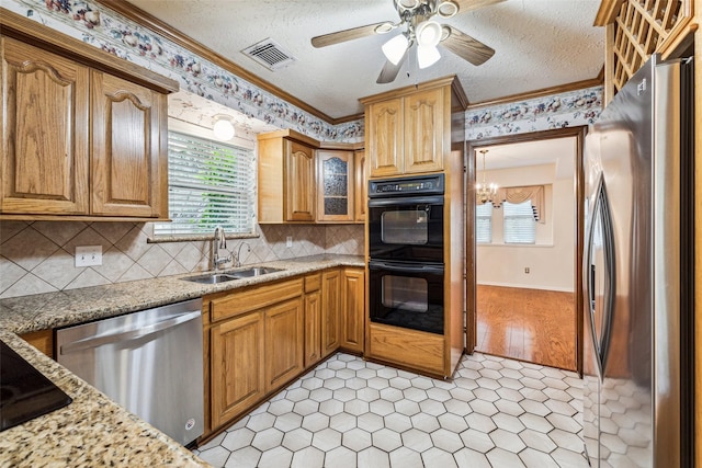kitchen with stainless steel appliances, a sink, a ceiling fan, crown molding, and a textured ceiling