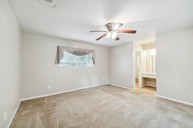 unfurnished bedroom featuring carpet, baseboards, connected bathroom, and ceiling fan