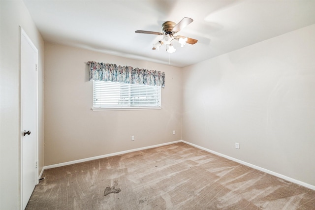 carpeted empty room with ceiling fan and baseboards