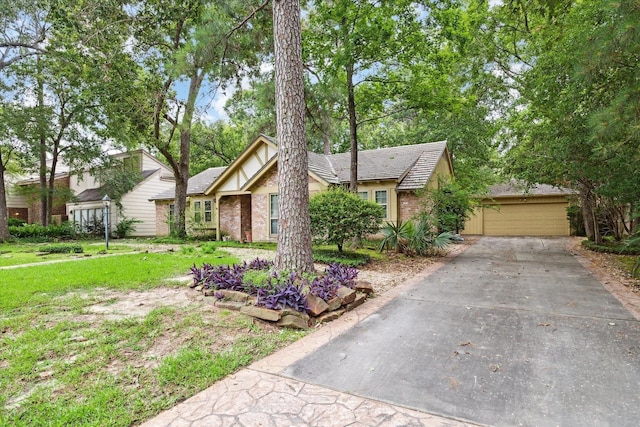 view of front facade with brick siding, a garage, a front yard, and concrete driveway