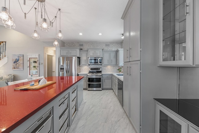7 N Flamingo St, La Marque, TX 77568 - kitchen with stainless steel appliances, gray cabinets, recessed lighting, light marble finish floors, and decorative light fixtures