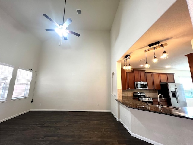 13842 Evansdale Ln, Houston, TX 77083 - kitchen with appliances with stainless steel finishes, dark wood-style floors, ceiling fan, high vaulted ceiling, and dark stone countertops