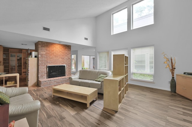 11414 Cedar Creek Dr, Houston, TX 77077 - living area with light wood-style floors, high vaulted ceiling, a brick fireplace, plenty of natural light, and baseboards