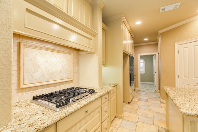 106 Arrowhead Dr, Lake Jackson, TX 77566 - kitchen featuring cream cabinets, stainless steel gas stovetop, crown molding, light stone countertops, and oven