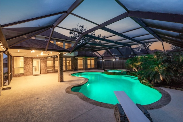 106 Arrowhead Dr, Lake Jackson, TX 77566 - pool at dusk featuring a patio, a pool with connected hot tub, a lanai, and fence