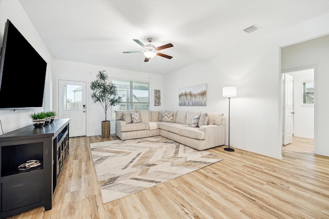 living room featuring light wood-style flooring, ceiling fan, and baseboards