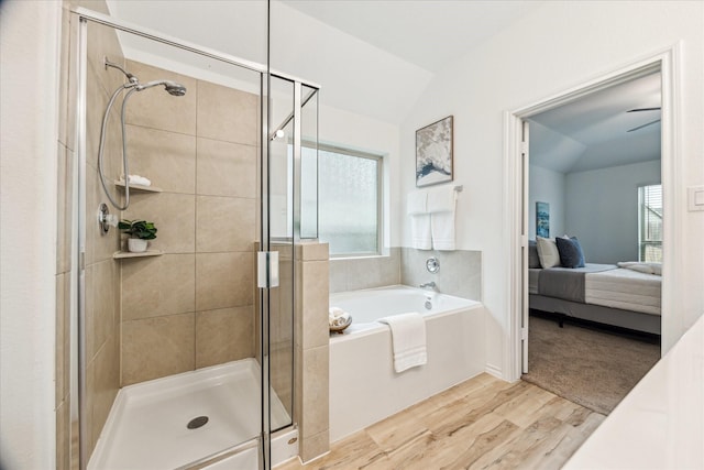 full bath with ensuite bath, a shower stall, a garden tub, wood finished floors, and plenty of natural light